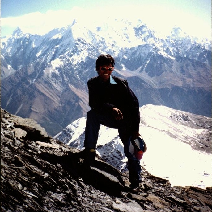 Nima Lakpa Sherpa on summit of Thapa Peak with Annapurna Himal in background