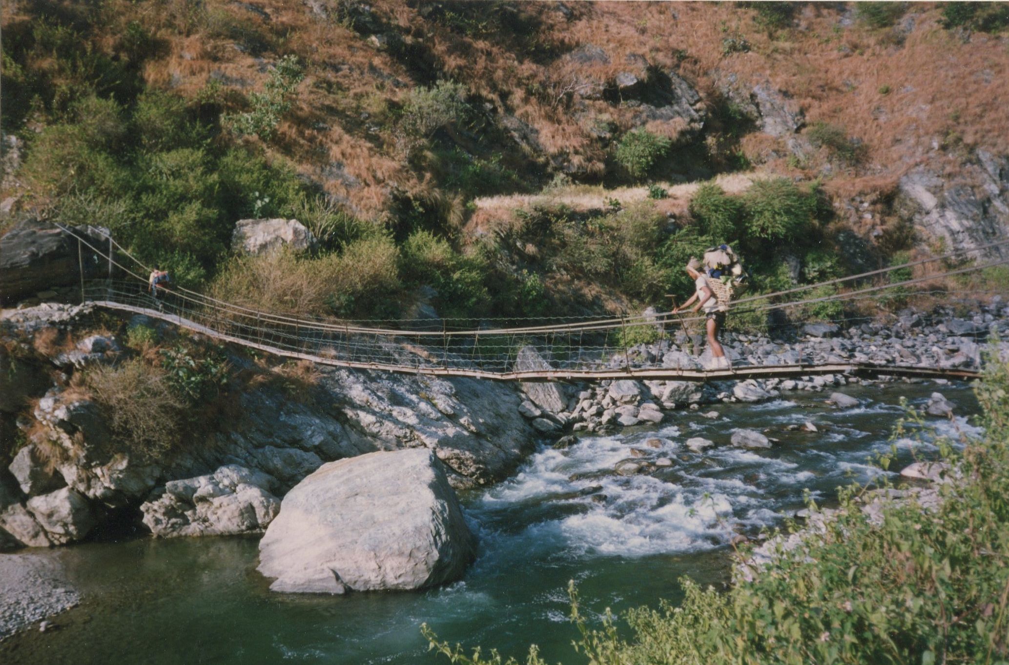 Nepalese Porter crossing Suspension Bridge across the Kabeli Khosi to Yamphudin Village