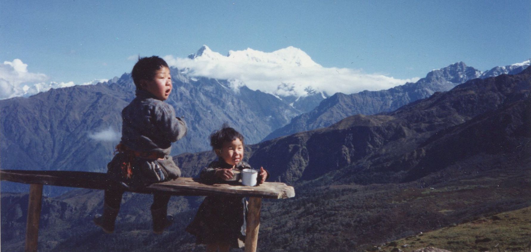 Nepalese children and Mount Langtang Lirung ( 7227m ) on ascent from Syabru to Gosaikund