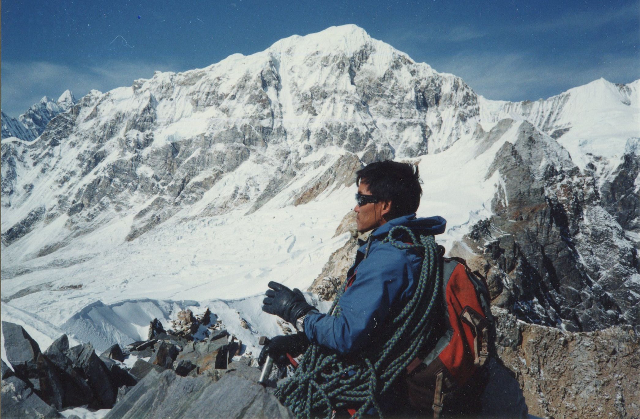 Nima Gyalzen Sherpa on summit of Yala Peak with Shalbachum in background