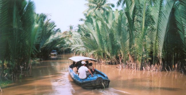 Boat in narrow waterway of Mekong Delta