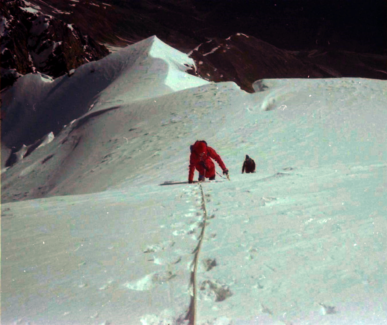 Climbing steep snow slopes to summit